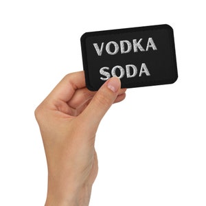 May include: A black fabric patch with white embroidery that reads "VODKA SODA".