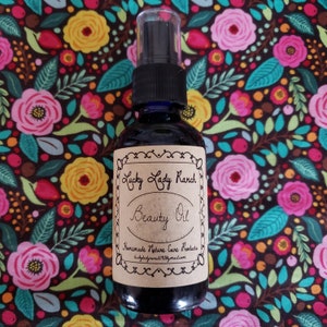 May include: A brown glass bottle with a black spray top and a brown paper label that reads "Lucky Lady Ranch Beauty Oil Homemade Nature Care Products luckyladyranch@gmail.com".