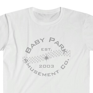 Puede incluir: Camiseta blanca con un gráfico circular gris que dice "Baby Park Amusement Co. Est. 2003" con un patrón a cuadros y una estrella.