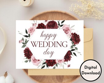 May include: Printable digital download of a wedding card with a burgundy and pink floral wreath and the text "happy wedding day".
