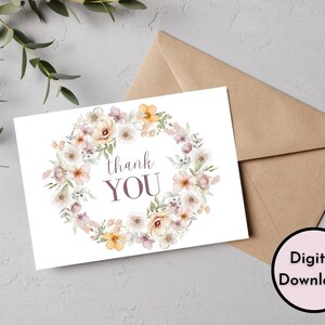 May include: A printable thank you card with a watercolor wreath of flowers in shades of pink, peach, and yellow. The text "thank you" is written in purple.