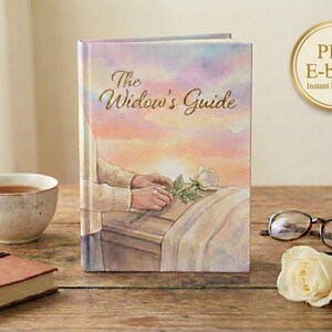 Könnte beinhalten: Ein Hardcover-Buch mit dem Titel "The Widow's Guide" mit einer Aquarellillustration von Händen, die eine Rose auf einen Sarg legen. Eine Tasse Tee, ein Notizbuch, eine Brille und eine Rose liegen auf einer Holzoberfläche.