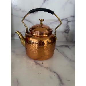 Tetera de cobre martillado vintage para estufa con detalles de latón, decoración rústica.