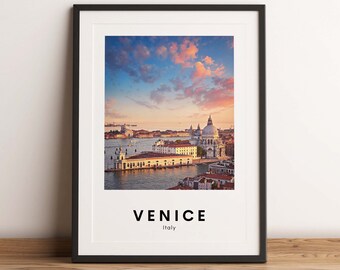 May include: A framed print of a cityscape with a pink and blue sky. The city is Venice, Italy. The text "VENICE" and "Italy" is printed below the image.