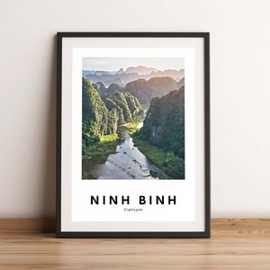 May include: A framed print of a landscape scene with a river winding through a valley of green mountains. The text "NINH BINH Vietnam" is printed below the image.