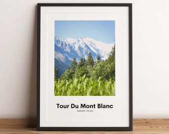 May include: Framed print of the Tour Du Mont Blanc in Europe, displaying snow-covered mountains, green trees, and grass under a blue sky. The text "Tour Du Mont Blanc" is at the bottom. The distance is 170 km.