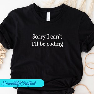 Może przedstawiać: Czarny T-shirt z białym tekstem, który brzmi "Przepraszam, nie mogę, będę kodować".