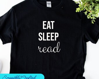 May include: Black t-shirt with white text that reads "Eat Sleep read" in a cursive font.