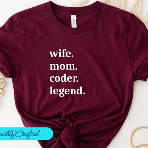 May include: Burgundy t-shirt with white text that reads "wife. mom. coder. legend."