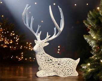 May include: White, decorative, reindeer figurine with a detailed, intricate, mesh-like design. The reindeer is sitting with its head turned to the side.