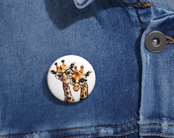 May include: A white button with a cartoon image of two giraffes wearing glasses. The giraffes are brown and yellow with black spots. The button is 1 inch in diameter.