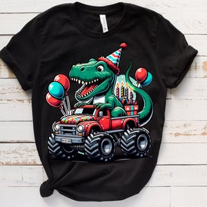 Może przedstawiać: Czarny T-shirt z zielonym dinozaurem w czapce urodzinowej, jadącym czerwonym monster truckiem z urodzinowymi świeczkami i prezentami. Dinozaur trzyma prezent w pysku.