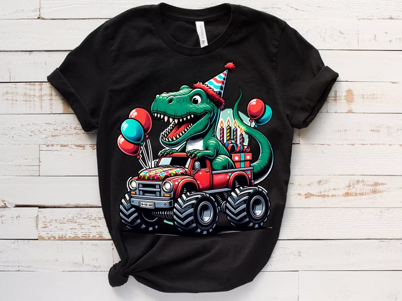 Może przedstawiać: Czarny T-shirt z zielonym dinozaurem w czapce urodzinowej, jadącym czerwonym monster truckiem z urodzinowymi świeczkami i prezentami. Dinozaur trzyma prezent w pysku.