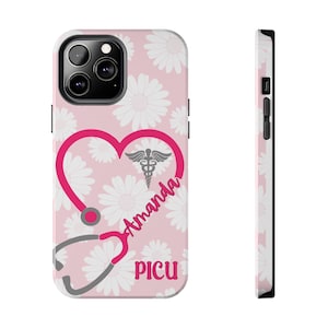 Puede incluir: Funda de teléfono rosa con un diseño de margaritas blancas. Un estetoscopio rosa intenso forma un corazón, con el nombre "Amanda" y el acrónimo "PICU" en rosa. Un símbolo médico está dentro del corazón.