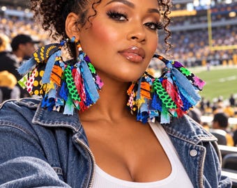 May include: Large hoop earrings featuring a dense fringe of multicolored fabric strips in various patterns including polka dots, floral prints, and solid blue denim. The fabric strips are attached to a circular frame with small beads at the top.