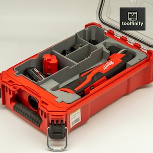 May include: A red tool case with a clear lid, containing a Milwaukee brand power tool, two batteries, and other accessories. The case has a handle and a latch.