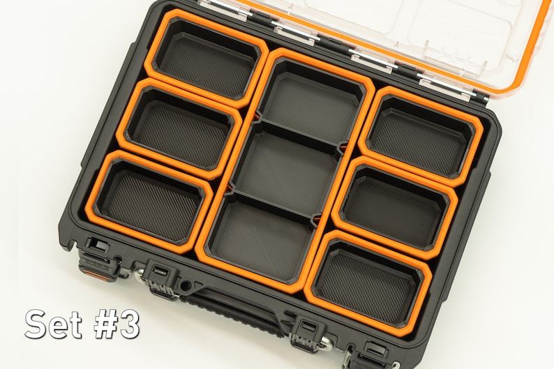 Puede incluir: Una caja de almacenamiento de pl&aacute;stico negro con un borde naranja, que contiene m&uacute;ltiples bandejas negras extra&iacute;bles con un borde naranja. La caja est&aacute; abierta y las bandejas son visibles. El texto "Set #3" es visible en la esquina inferior izquierda de la imagen.