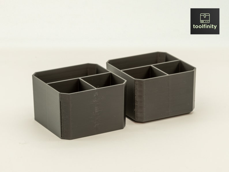 May include: Two grey plastic desk organisers with four compartments each. The organisers are made of a textured plastic and have a rectangular shape.