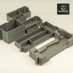 May include: A gray plastic organizer with multiple compartments of different sizes. The organizer is designed to hold small items and tools.