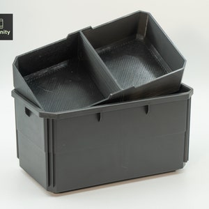 May include: Two-piece, dark grey storage containers. The top container has two compartments and sits on top of a larger, rectangular container. The containers are made of a matte material. The logo "toolfinity" is in the top left corner.