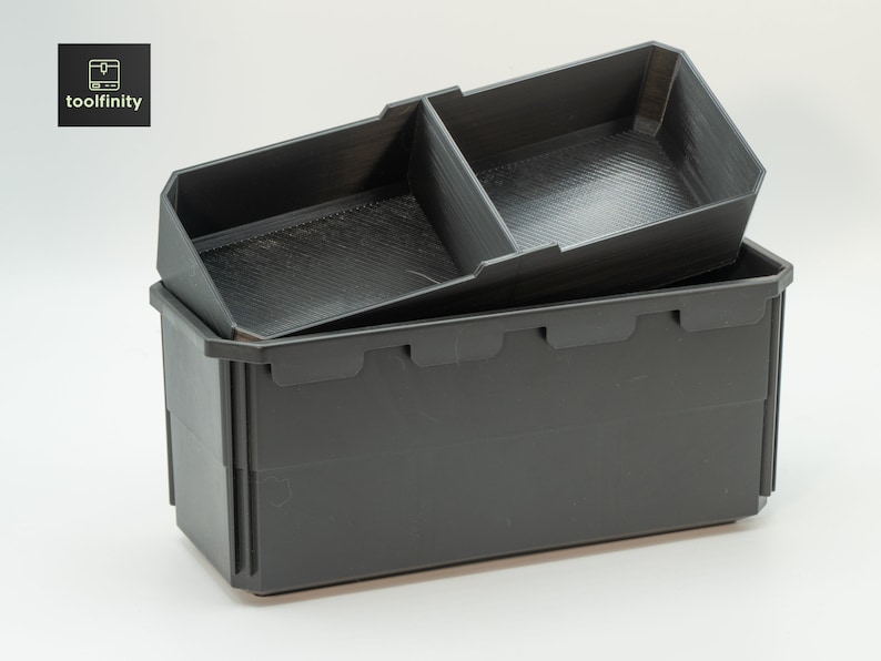 Pu&ograve; includere: Due contenitori di stoccaggio in plastica nera, uno annidato nell'altro. Il contenitore pi&ugrave; piccolo ha un divisorio, creando due scomparti.