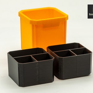 May include: Two black plastic organisers with four compartments each, and a larger orange plastic container.