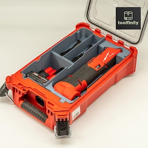 Peut inclure: Une mallette à outils rigide rouge et noire avec un couvercle à charnière, dotée d'un insert de rangement gris. À l'intérieur, un outil électrique rouge et noir et une batterie sont rangés. Le couvercle porte un logo toolfinity.