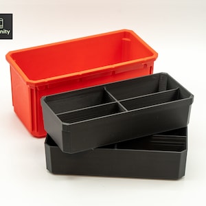 May include: Two plastic storage containers, one red and one black. The black container has dividers inside to create compartments. The containers are stacked on top of each other.