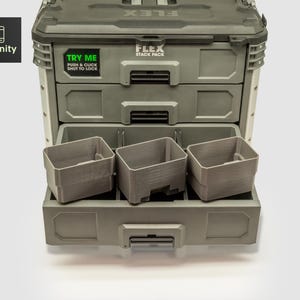 May include: A gray FLEX Stack Pack tool storage system with three drawers and three removable gray bins. The top drawer has a green sticker that says "TRY ME" and the text "PUSH & CLICK SHUT TO LOCK". The toolfinity logo is in the upper left corner.
