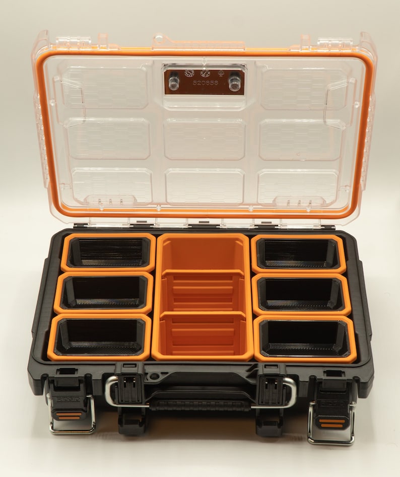 May include: A black and orange plastic storage box with a clear lid and multiple compartments. The lid has a latch with the number 520358 printed on it.