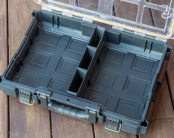 May include: Black plastic storage box with a clear lid and multiple compartments. The box has a handle and latches.