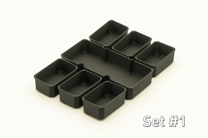Puede incluir: Conjunto de seis contenedores de almacenamiento de pl&aacute;stico negro con forma rectangular. Los contenedores est&aacute;n dispuestos en una cuadr&iacute;cula. El texto "Set #1" es visible en la esquina inferior derecha de la imagen.