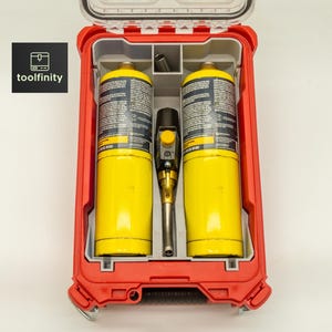 May include: A red toolbox with a clear lid, containing two yellow propane tanks and a black and silver torch. The toolbox has a gray interior and the text "toolfinity" on a black square.