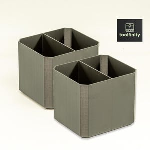 May include: Two gray, square-shaped, divided storage containers. Each container has two compartments.