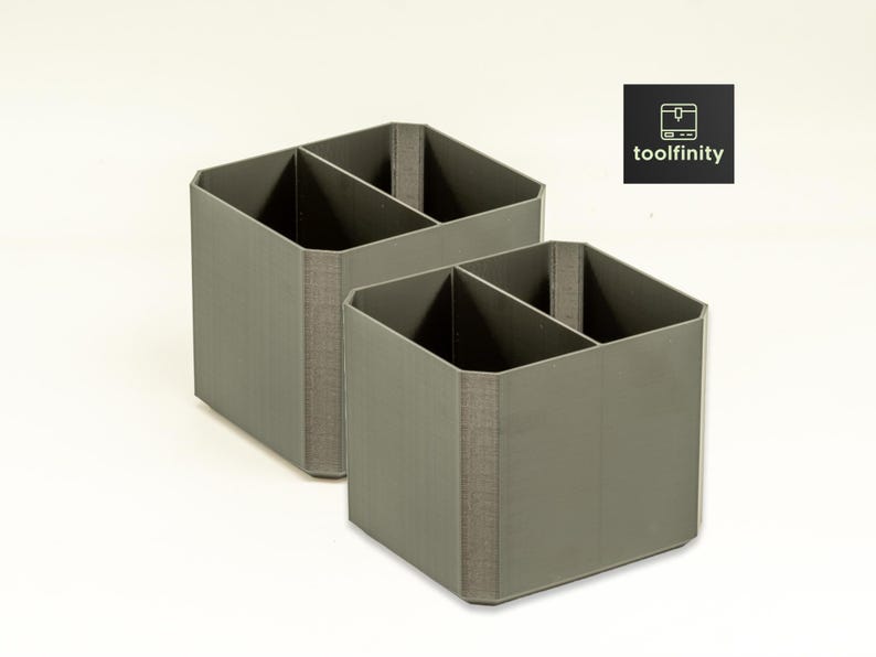 May include: Two gray, square-shaped, divided storage containers. Each container has two compartments.