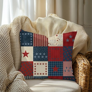 May include: A square throw pillow featuring a patchwork design with various red, white, and blue patterns. The squares include stars, stripes, polka dots, and plaid motifs, along with sections containing printed text in a vintage script style.