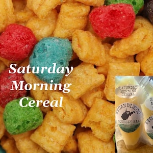 May include: A collection of colourful, crunchy cereal pieces in shades of yellow, red, green, and blue, with the text "Saturday Morning Cereal" overlaid. Two clear pouches of "Saturday Morning Cereal" squeezy wax are visible in the bottom right corner.