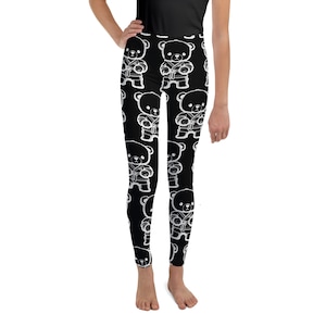 May include: Black leggings with a white repeating pattern of a cartoon bear wearing boxing gloves.