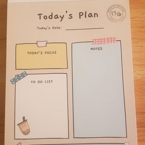 May include: A beige planner with a light brown border and the text "Today's Plan" in black. The planner has sections for "Today's Focus", "Notes", "To Do List", and "Today's Meditation & Self-Care". Each section has a decorative border and a small illustration.