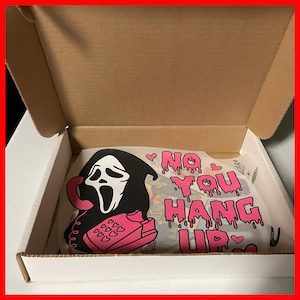 May include: A white cardboard box with a pink and black graphic design featuring a ghost face with a phone and the text "No You Hang Up".