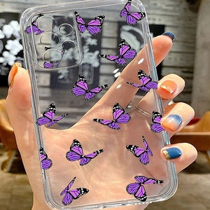 K&ouml;nnte beinhalten: Eine transparente Handyh&uuml;lle mit einem Muster aus lila Schmetterlingen. Die H&uuml;lle ist f&uuml;r ein Smartphone mit einer Kamerabuckel konzipiert.