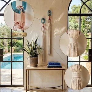May include: Two wall-mounted decorative hangings featuring translucent blue and pink resin chain links connected to long, dense cream-colored cotton tassels. The image includes circular callouts labeled DETAIL: BLUE GLASS & PINK RESIN LINKS and DETAIL: DENSE COTTON TASSEL WEAVE.