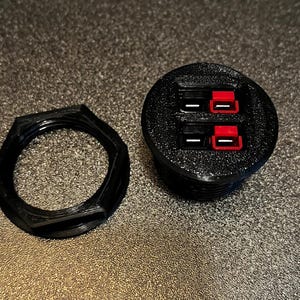 Puede incluir: Una tapa de toma de corriente eléctrica de plástico negro con dos puertos USB rojos.