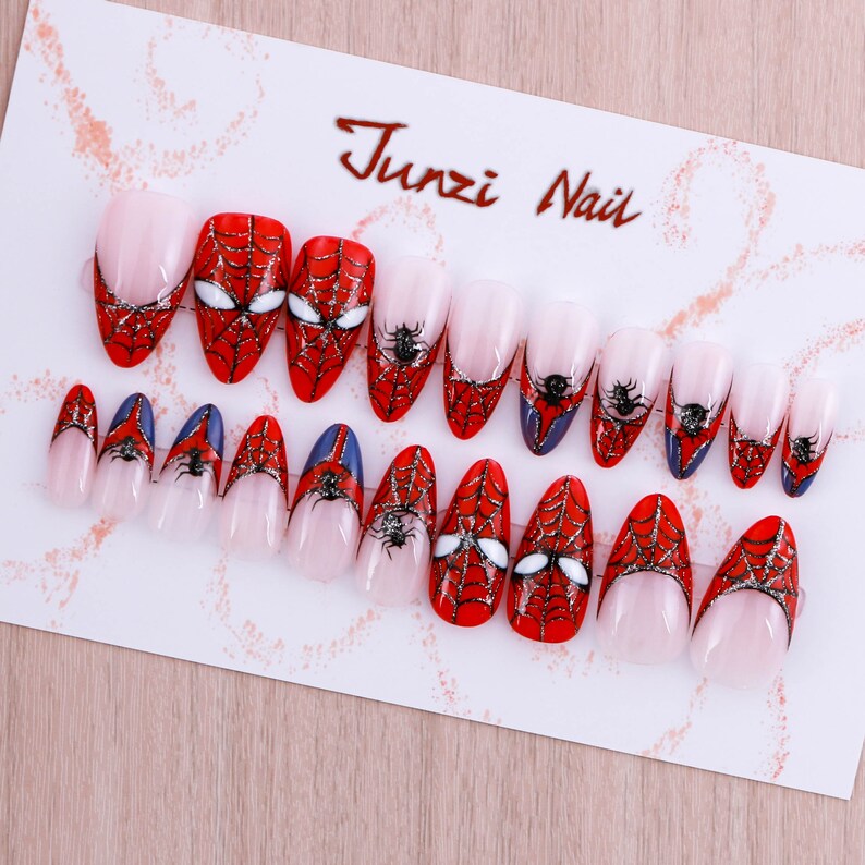 Puede incluir: Conjunto de 14 u&ntilde;as postizas con un dise&ntilde;o de telara&ntilde;a roja y negra. Las u&ntilde;as est&aacute;n decoradas con un patr&oacute;n de telara&ntilde;a y una ara&ntilde;a. Las u&ntilde;as son de varios tama&ntilde;os y formas. Junzi Nail est&aacute; impreso en la tarjeta.