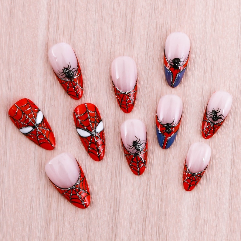 Puede incluir: Diez u&ntilde;as postizas con un dise&ntilde;o de Spiderman rojo y negro. Las u&ntilde;as son de diferentes formas y tama&ntilde;os, pero todas tienen el mismo dise&ntilde;o.