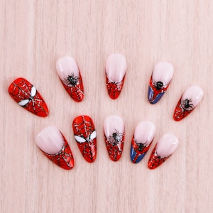Puede incluir: Diez puntas de u&ntilde;as rojas y negras con un dise&ntilde;o de telara&ntilde;a. Las puntas de las u&ntilde;as est&aacute;n pintadas con un dise&ntilde;o de telara&ntilde;a roja y negra.