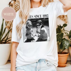 K&ouml;nnte beinhalten: Wei&szlig;es T-Shirt mit einem Schwarzwei&szlig;foto von zwei M&auml;dchen mit Sonnenbrillen und dem Text "Besties Since 1993".