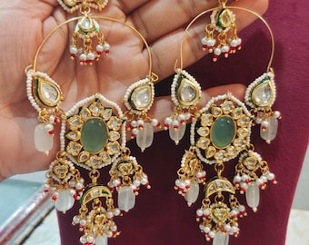 Puede incluir: Un par de pendientes de aro de oro con piedras verdes y blancas, cuentas rojas y perlas blancas. Los pendientes son colgantes y tienen un diseño floral.