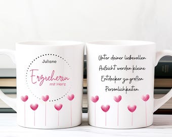 May include: White ceramic mug with a pink heart design and the text "Juliane Erzieherin mit Herz" on one side and the text "Unter deiner liebevollen Aufsicht werden kleine Entdecker zu großen Persönlichkeiten." on the other side.