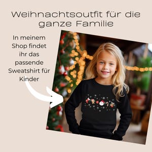 May include: A young girl wearing a black sweatshirt with a Christmas-themed design. The design includes Santa Claus, gingerbread men, candy canes, and snowflakes. Text on the image reads "Weihnachtsoutfit f&uuml;r die ganze Familie" and "In meinem Shop findet ihr das passende Sweatshirt f&uuml;r Kinder."